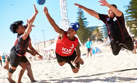 Two members (left and right in black) of the American Samoa National Men’s Beach Handball Team