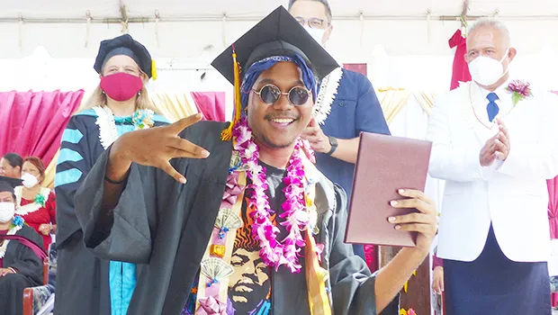 ASCC grad with his diploma, Lt. Gov in the background