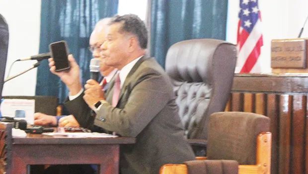 Homeland Security director Samana Semo Ve’ave’a holds up an iPhone