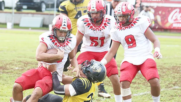 Faga’itua Vikings O’Neil Ah-Chee struggling to break a tackle against a Nu’uuli Wildcats defender 