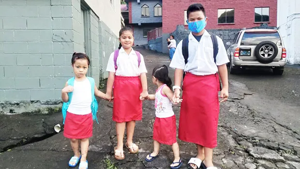 Matafao Elementary School students holding hands on their way to school