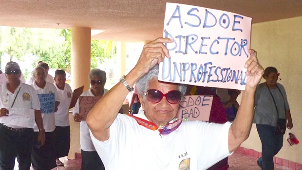 Man holds sign saying ASDOE director is unprofessional