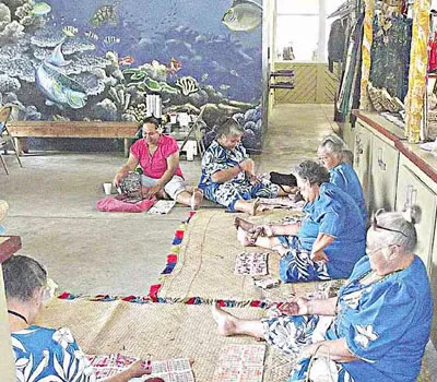 Wiomen sitting on the ground playing BINGO