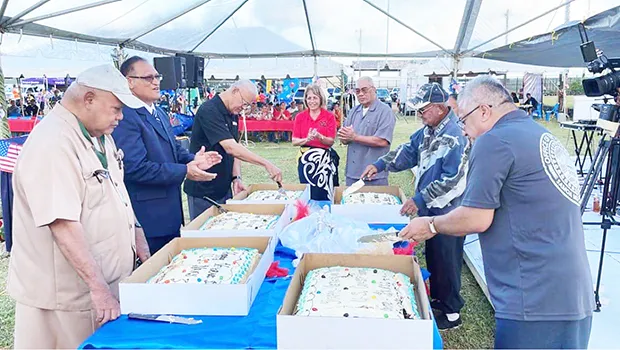 Veterns cutting the cake at a Pre-Veterans Day block party