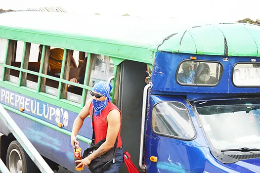 Man with scarf face covering exits a bus
