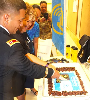 US Army Capt. Kurk Cruz Diaz, the Guam Recruitment Company Commander, with Bluesky official Sherry Sele, cutting the cake yesterday as part of the signing ceremony for the Army Partnership for Youth Success (PaYS) program with Bluesky Communications.  [photo: FS]