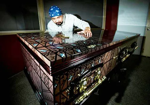 Artist and signage Specialist Pomare Amosa with one of the caskets he has decorated