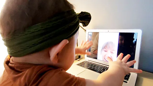 Young cild interacts on woman on a video chat. 