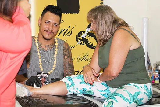 Christopher Adolfo Krieg smiles for the Samoa News Camera while tattooing a tourist