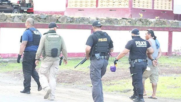 Police officers leading a suspect away 