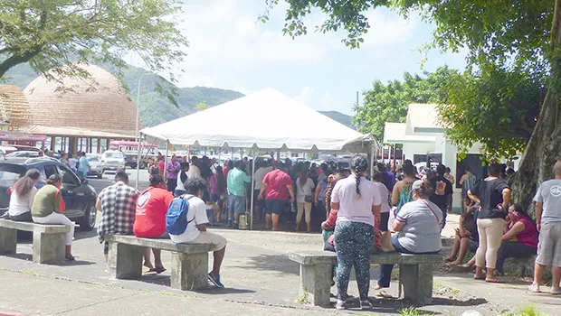 A crowd gathered at Social Service office under the tents with no social distancing
