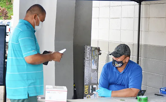 Customs agent inspecting a package of person picking up at post office
