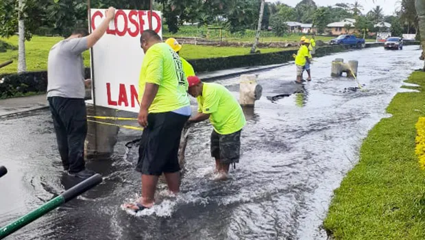 DPW crew installing lane closed sign where Fagaima road is flooded