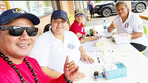 Three HR staffers manning a Tonga relief donation booth