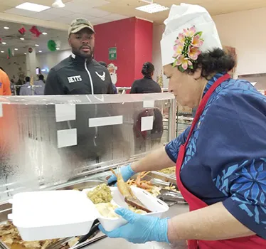 Congresswoman Aumua Amata dishing up food for troops