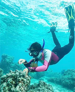 Molina swimming over a reef in snorkle gear