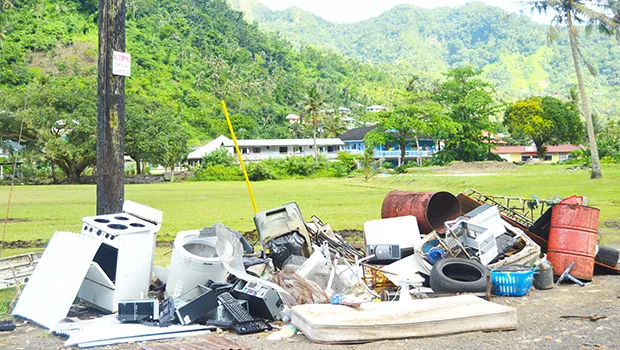  various types of garbage being dumped under and near the pole
