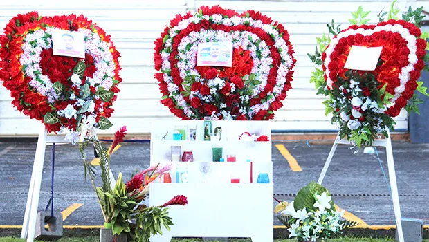 Flowers with photographs in place at the site where three Manu'a Store employees died