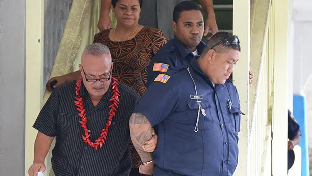 Deputy Commissioner Falana’ipupu Ta’ase Sagapolupele (left) and two other police officers escorting Police Officer Fa’auma Malo (right) after his arrest in 2017