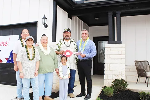 Taetuli and family in front of their new home.