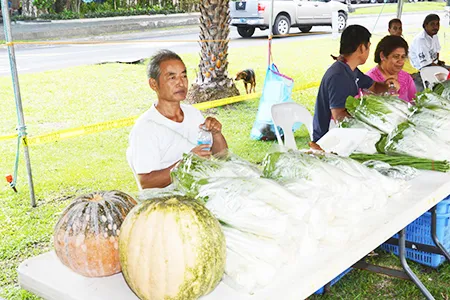 A farmer in American Samoa displays his produce at a farmers market