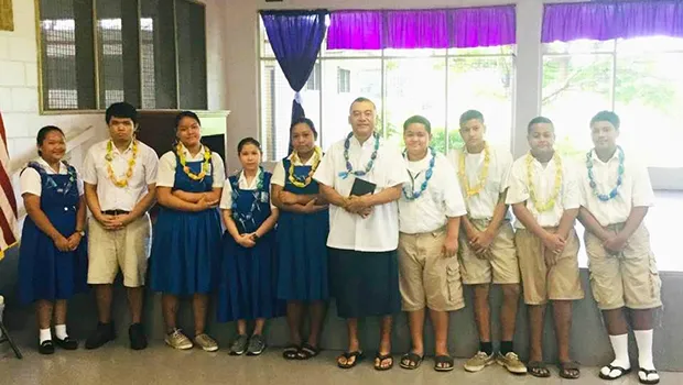 Rev. Father Kolio Etuale (middle) surrounded by students of St. Theresa Elementary School