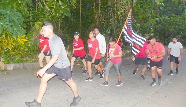 Members of the community march to honor fallen firefighters