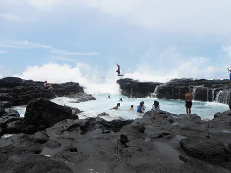 Kids jumping into an ocean tide pool
