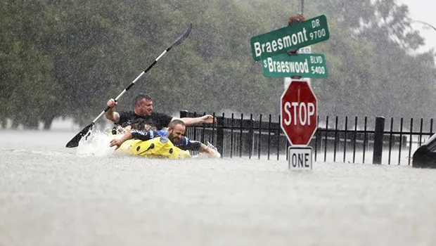 Flooding in Houston with two men paddling in the water
