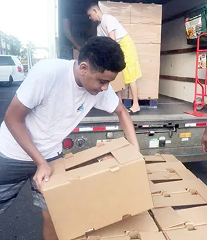 Ā’oga Samoa boys unloading cartons of food