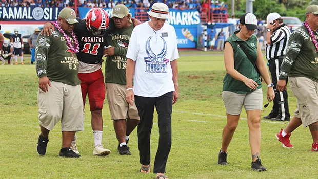 ASHSAA ATC Florence Wasko (right) and Dr. Edwards leading off the injured Manuita Sofeni of