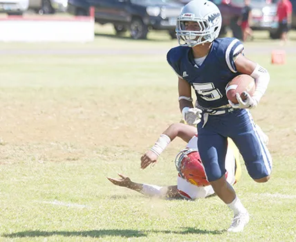Samoana Sharks Sophomore at running back, Marcus Samia beating a Tafuna defender