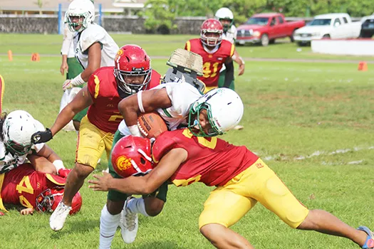 Joshua Taani of the Leone Lions is met by a Tafuna Warrior defender