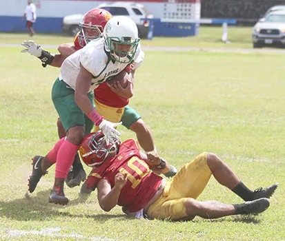 A Leone Lion defender tries to break away from two Tafuna Warriors