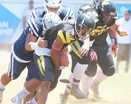 Joe Savaii trying to escape the grasp of a Samoana defender 