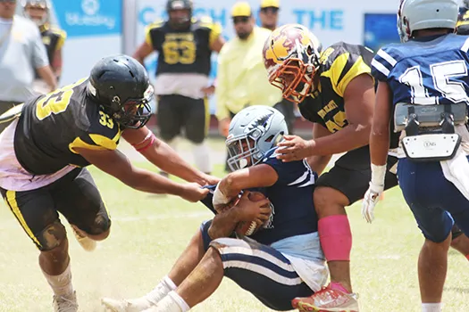 Charlie Toa Leama of Nu’uuli and a teammate sack Samoana’s quarterback Viliamu Tanielu