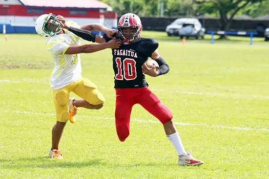 Faga’itua Viking’s Scott Pese (10) puts a stiff arm to the face of a Leone defender