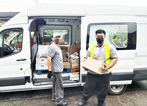Two men and truck with food for delivery