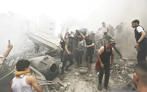 Palestinians remove a dead body from the rubble of a building after an Israeli airstrike