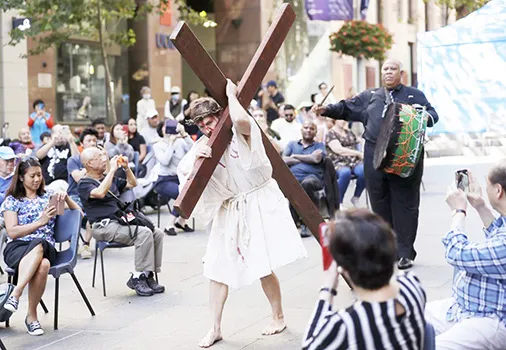 Actor Timothy Watkins carries a cross 