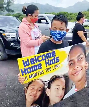 Young boy holding welcome banner