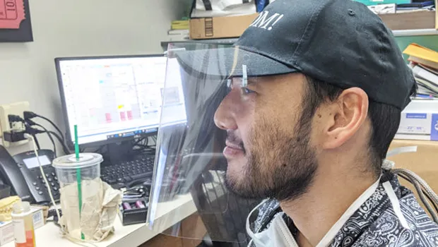 Dr. Eric Muraoka wearing one of his face shields he printed on his 3-D printer