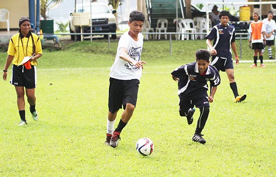 An Ilaoa & To’omata player (left) dribbles away from a Black Roses’ opponent