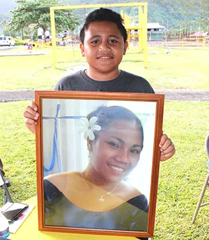 Eleven-year-old Malakai, posing for Samoa News with a portrait of his mother, Sabrina Seva’aetasi