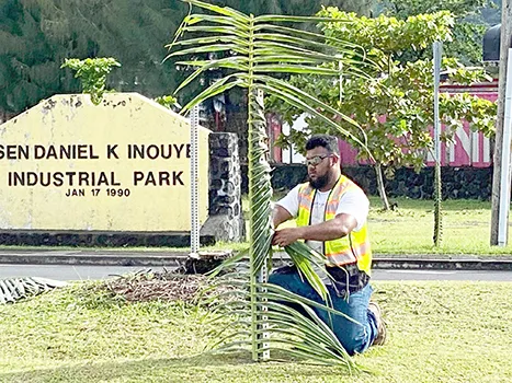 The  Sen. Daniel K. Inouye Industrial Park sign with man 