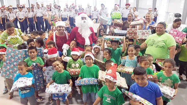 Tafuna ECE students with gifts from Tafuna High School JROTC in background