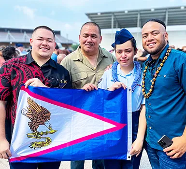 Kathlynn Faaita with family holding an American Samoa flag
