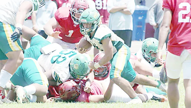 Leone Lions running back Wylan Faga avoids a pile-up and continues to run