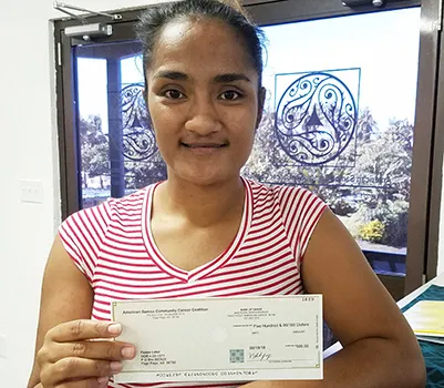 Fuaao Letoi's daughter is pictured receiving Fuaao's 2nd stipend