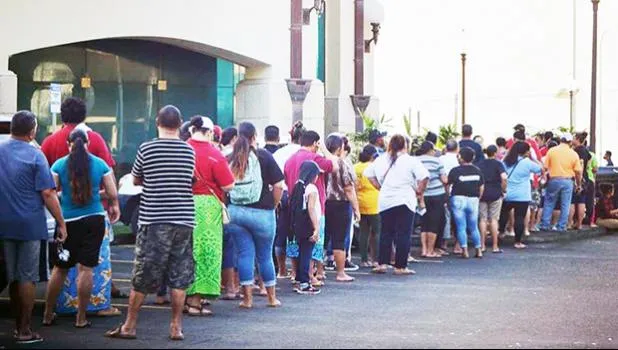 A crowd of people seen standing in line outside of the Territorial Bank of American Samoa (TBAS) waiting for the bank to open so they could cash their stimulus checks